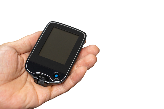 Hand holding a blood glucose meter