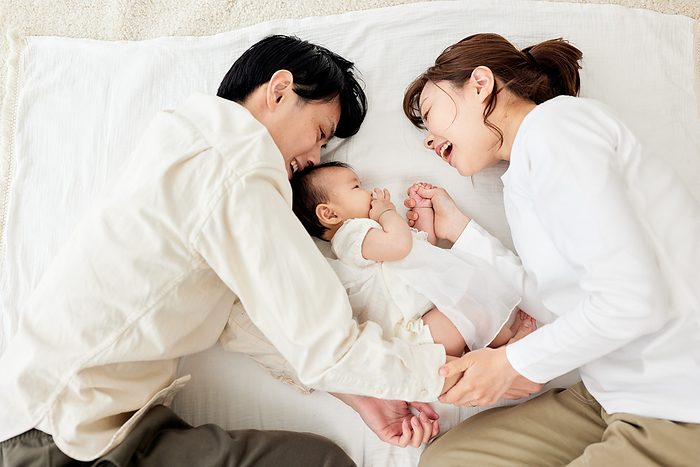 Japanese couple snuggling with their baby