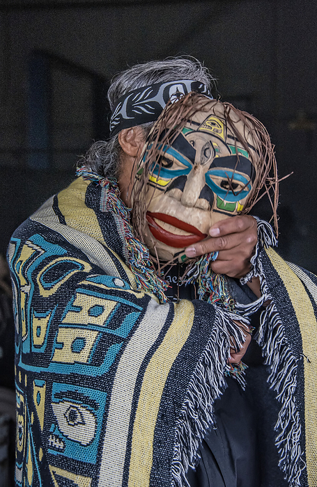 Native American man with mask Man stands draped in a blanket with Native Indian design and holding a mask to obscure his face  Hoonah, Alaska, United States of America, Photo by Karen Kasmauski   Design Pics