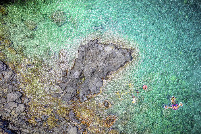 Drone view from directly above over swimmers in the clear, turquoise Pacific Ocean water along the rugged coastline of Maui, Hawaii, USA; Kapalua, Maui, Hawaii, United States of America, Photo by Living Moments Media / Design Pics
