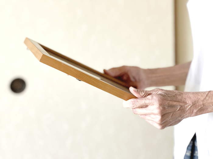 Elderly woman's hand holding a portrait
