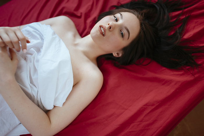 Woman lying on a red sheet with her hair down
