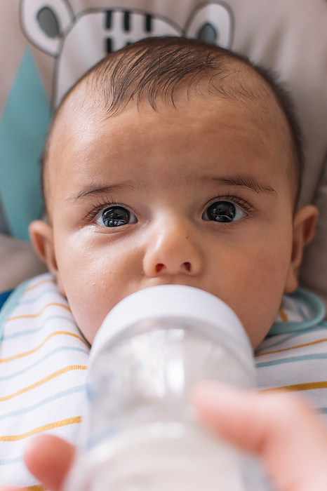 Baby drinking milk from a feeding bottle.