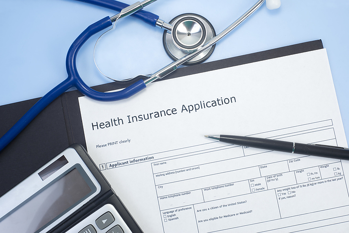 Health insurance application Application for health insurance with stethoscope, calculator, and pen., by SHERRY YATES YOUNG SCIENCE PHOTO LIBRARY