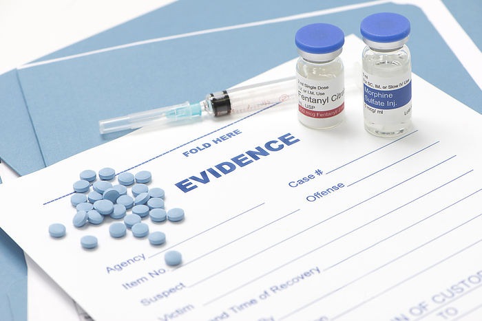 Morphine and fentanyl evidence collection form Illegal drugs. Fentanyl and morphine vials with morphine pills, on law enforcement evidence collection form., by SHERRY YATES YOUNG SCIENCE PHOTO LIBRARY