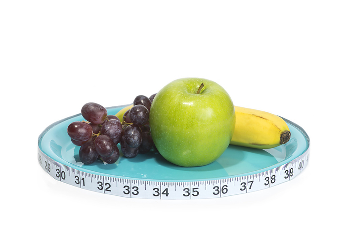 Healthy diet, conceptual image Healthy choice of fruit on plate with tape measure., by SHERRY YATES YOUNG SCIENCE PHOTO LIBRARY