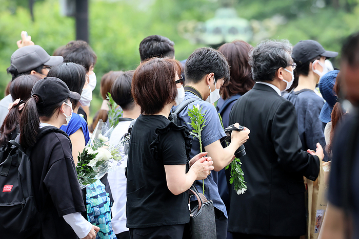 A hearse carrying body of former Prime Minister Shinzo Abe passes the prime minister s official residence after the funeral ceremony July 12, 2022, Tokyo, Japan   People make a long line to offer flower bouquets on an altar before starting the funeral ceremony of former Japanese Prime Minister Shinzo Abe at the Zojoji temple in Tokyo after the funeral ceremony while police officers bow their heads and salute on Tuesday, July 12, 2022. Abe was shot dead at a stamping tour in western Japan for the Upper House election on July 8.       Photo by Yoshio Tsunoda AFLO 
