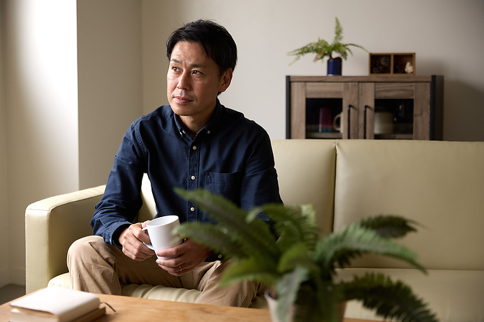 Japanese man relaxing on a sofa