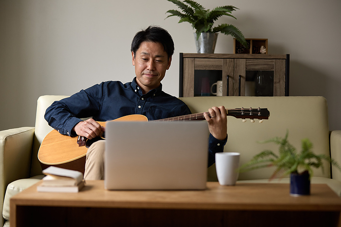Japanese man playing acoustic guitar