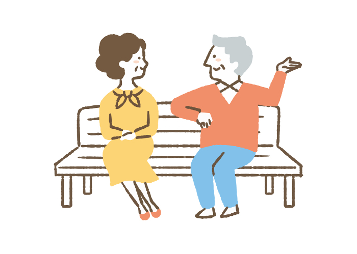 Elderly couple sitting on bench talking_Color