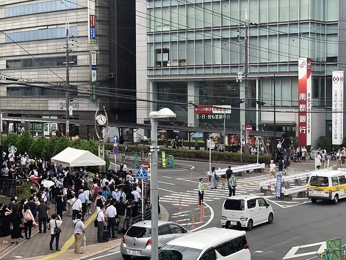 Former Prime Minister Abe killed by gunfire, many flowers at the scene. People gather at a floral tribute stand near the crime scene  right  on July 15, 2022, one week after former Prime Minister Shinzo Abe was shot at Yamato Saidaiji Station  photographed at  Yamato Saidaiji Station