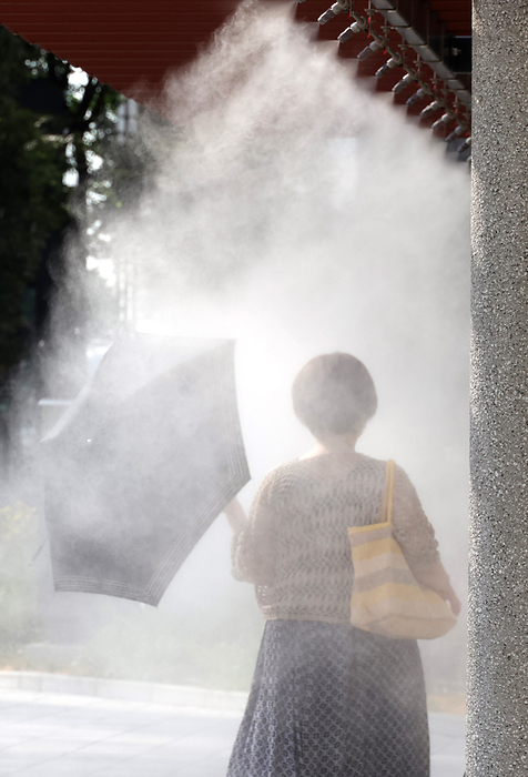 Extreme heat throughout Japan August 2, 2022, Tokyo, Japan   A woman gets water mist shower to cool down in Tokyo on Tuesday, August 2, 2022. Japan s temperature climbed to around 40 degree Celsius and the government warned people against heat stroke.        Photo by Yoshio Tsunoda AFLO  