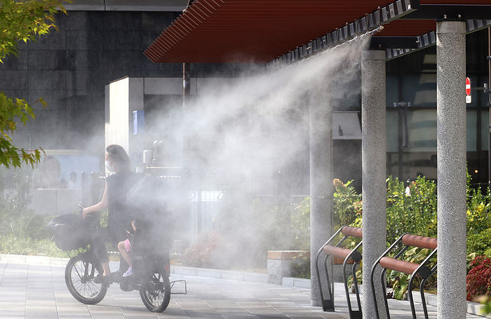 Extreme heat throughout Japan August 2, 2022, Tokyo, Japan   A cyclist gets water mist shower to cool down in Tokyo on Tuesday, August 2, 2022. Japan s temperature climbed to around 40 degree Celsius and the government warned people against heat stroke.        Photo by Yoshio Tsunoda AFLO  