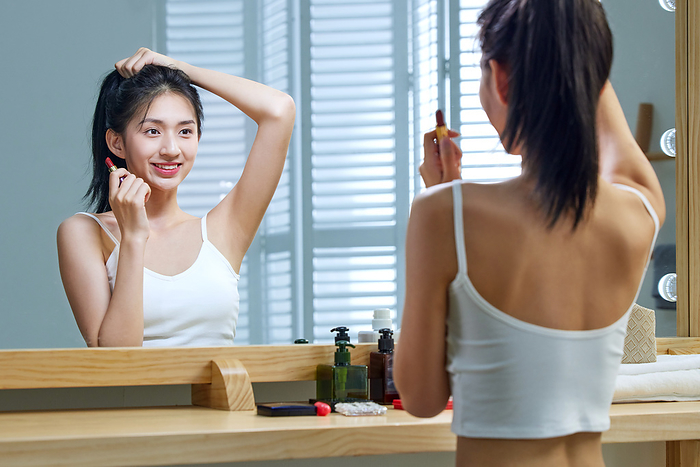 A beautiful young woman look into a mirror whilst combing your hair