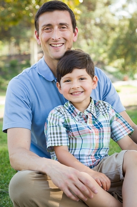 mixed-race father and son playing together in the park