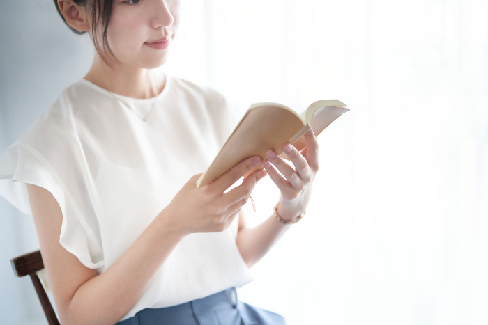 Japanese woman reading a book indoors (People)