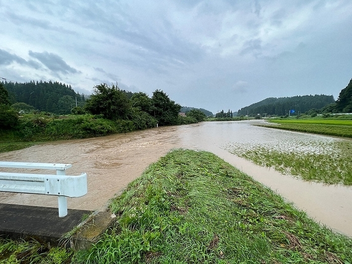 The Mikane River overflowed, pouring muddy water into the rice paddies on the right side, and by noon on the 10th, the water level had risen to the bridge in front of the house. The Mikane River overflowed, pouring muddy water into the rice paddies on the right side, and by midday on August 10, the water level had risen to the bridge in front of the river. August 10, 2002, photo by Takeyuki Sato