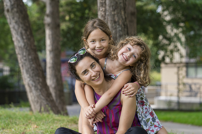 Portrait of a mother with two young daughters in a park; Toronto, Ontario, Canada, Photo by Ian Taylor / Design Pics