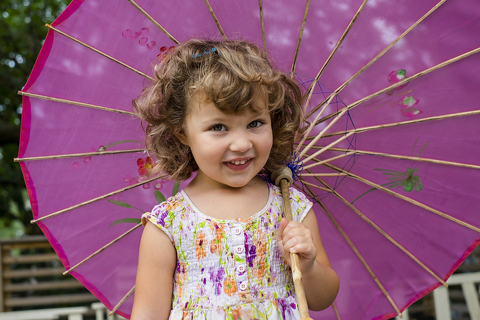 Preschooler girl with pink parasol; Toronto, Ontario, Canada, Photo by Ian Taylor / Design Pics