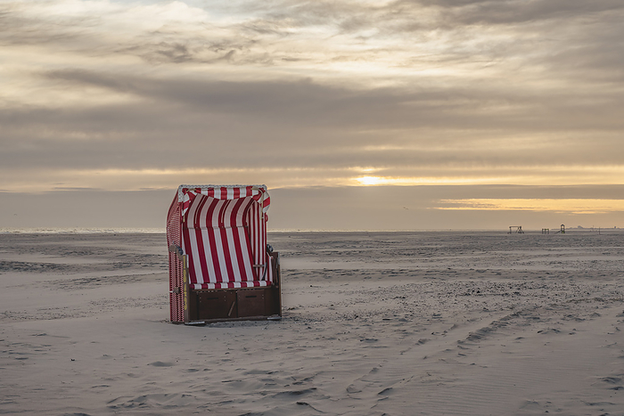 Germany Germany, Lower Saxony, Juist, Hooded beach chair on empty beach at sunset