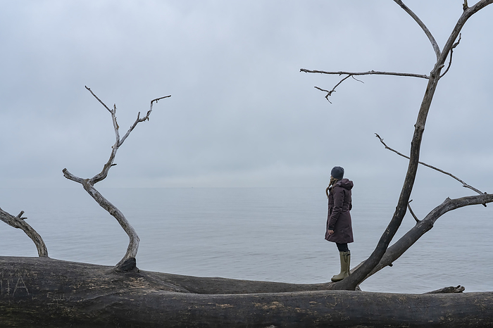 Woman standing looking out over the lake surrounding Point Pelee National Park, Ontario; Point Pelee, Ontario, Canada, Photo by Robert Postma / Design Pics