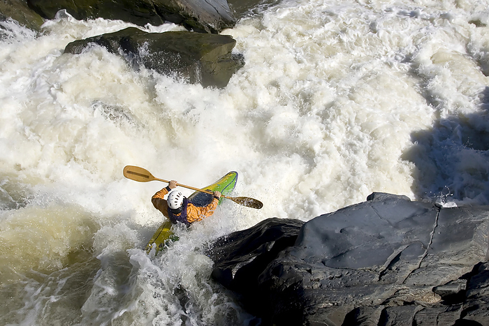 A kayaker paddles off a waterfall into big whitewater.; Great Falls, Potomac River, Virginia., Photo by Skip Brown / Design Pics
