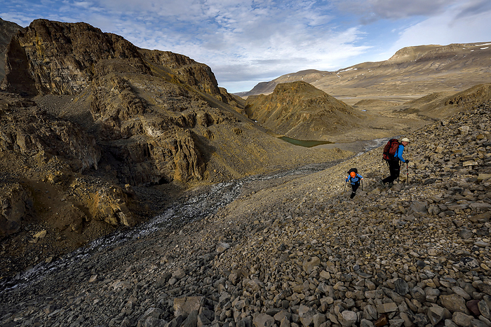 After finishing recording and documenting the first cave the team encounted, expedition team members climb one of the many scree slopes of rocks up onto another level to find the more larger and significant caves that they had previously read about., Photo by Robbie Shone / Design Pics