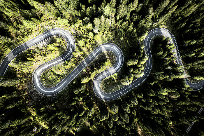 Overhead aerial view of hairpin bends of scenic mountain road crossing a green forest, Giau Pass, Dolomites, Veneto, Italy Overhead aerial view of hairpin bends of scenic mountain road crossing a green forest, Giau Pass, Dolomites, Veneto, Italy, Europe, Photo by Roberto Moiola