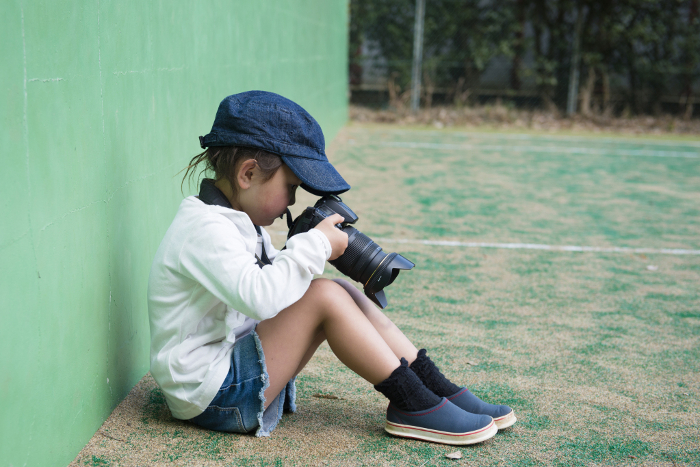 A child taking a picture with a single-lens reflex camera