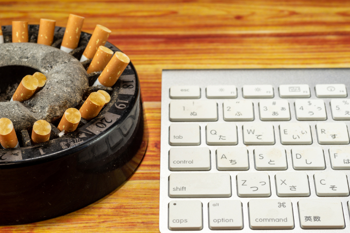 An ashtray full of cigarette butts and a keyboard