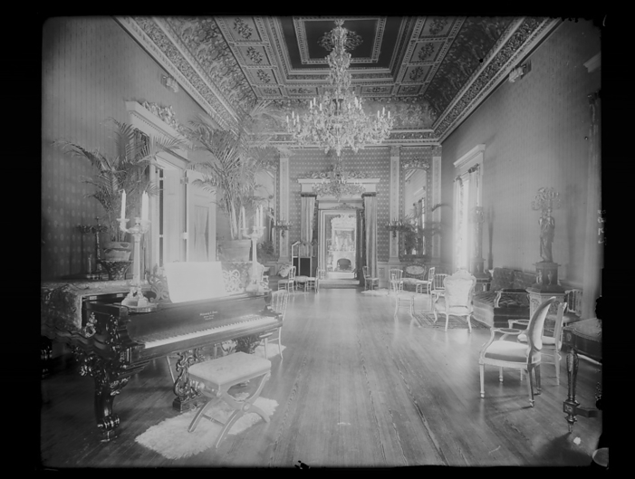 Interior view of a large hall with piano, chairs, small tables, and..., Washington, DC, c1890   1910 Creator: Frances Benjamin Johnston. Interior view of a large hall with piano, chairs, small tables, and sofas, chandeliers, ornate ceiling, and of a fireplace in the rear drawing room in the Corcoran House, formerly at the corner of H Street and Connecticut Avenue NW, Washington, D.C., between 1890 and 1910.