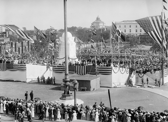 Columbus Memorial Unveiling, General View, 1912. Creator: Harris  amp  Ewing. Columbus Memorial Unveiling, General View, 1912.  The Columbus Fountain, also known as the Columbus Memorial, was unveiled in Washington, D.C. in 1912. The memorial,  behind flagpole , was designed by Lorado Taft. Seen here are crowds of people, with flag draped grandstands as part of the celebrations .