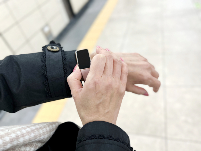 A woman's hand looking at her watch in the station aisle