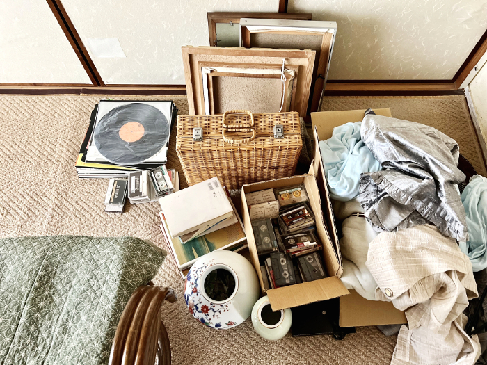 Picture frames, baskets, cassette tapes, rattan chairs, etc. being decluttered_overhead view
