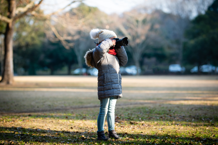 A child taking a picture with a single-lens reflex camera