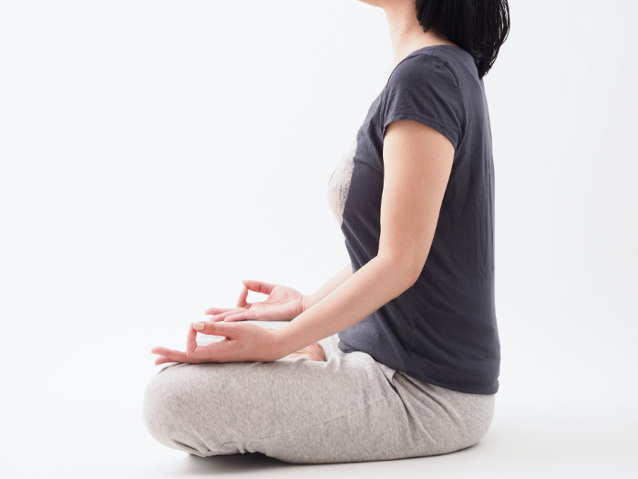 Woman meditating in white space