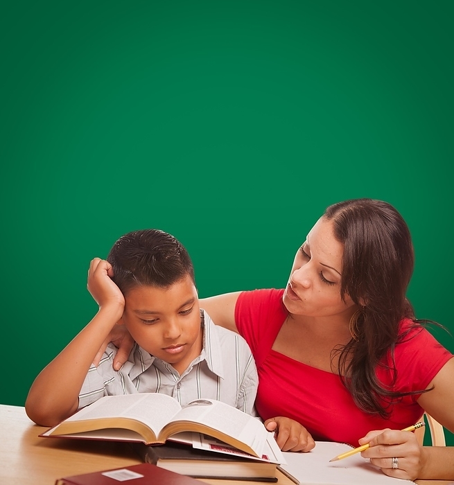 Blank chalk board behind hispanic young boy and famale adult studying, Photo by Andy Dean