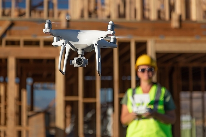 Female pilot flies drone quadcopter inspecting construction site, Photo by Andy Dean