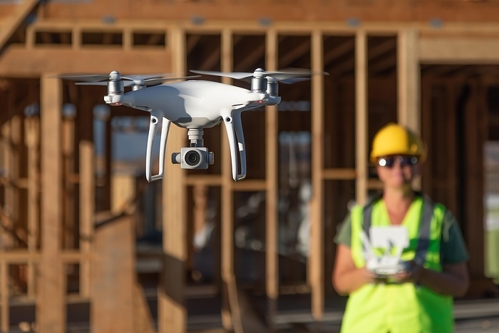 Female pilot flies drone quadcopter inspecting construction site, Photo by Andy Dean