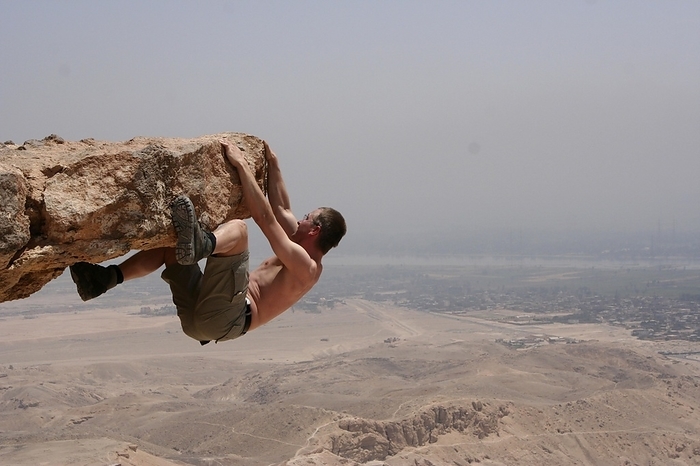 A brave climber hovers above the Valley of the Kings in Thebes West. In the background you can see the green ribbon of the Nile, Egypt, Africa, Photo by Erich Geduldig