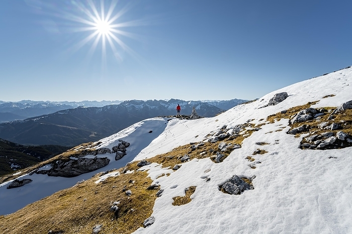 Hiker next to a cairn, in front of snowy mountains of the Rofan, hiking trail to the Guffert with first snow, in autumn, solar reflex, Brandenberg Alps, Tyrol, Austria, Europe, Photo by Mara Brandl