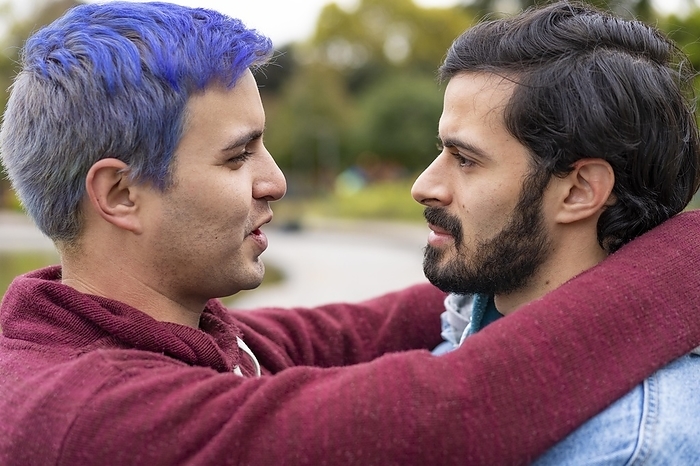 Latin gay couple hugging in a park looking at each other about to kiss, Photo by Mariano Gaspar