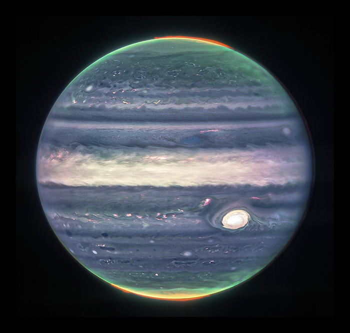 Jupiter, James Webb Telescope image Jupiter, composite James Webb Telescope image. This image uses three infrared filters to highlight different features of the gas giant planet. Aurorae above the north and south poles are red. Hazes swirling around the two poles are green and yellow. Light reflected from deeper main cloud is blue at lower altitudes and white at higher altitudes. The clouds of the Great Red Spot  lower right , a large storm system that has lasted for at least a few hundred years, appear white. Image obtained by the Near Infrared Camera  NIRCam ., by NASA, ESA, CSA, Jupiter ERS Team  Judy Schmidt SCIENCE PHOTO LIBRARY