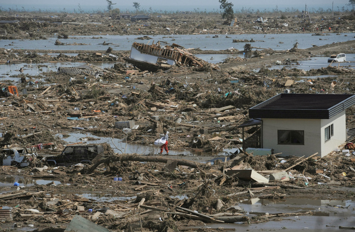 A man carries his belongings out of his house that was swept away by the Great East Japan Earthquake and Tsunami  Yamamoto, Miyagi A man carries his belongings out of his house  right , which was swept away 500 meters by the tsunami, in Yamamoto Town, Miyagi Prefecture.