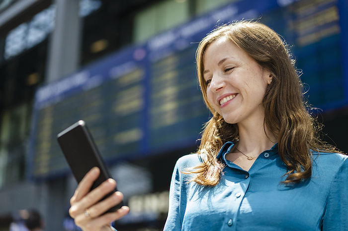 Smiling woman using smart phone on sunny day
