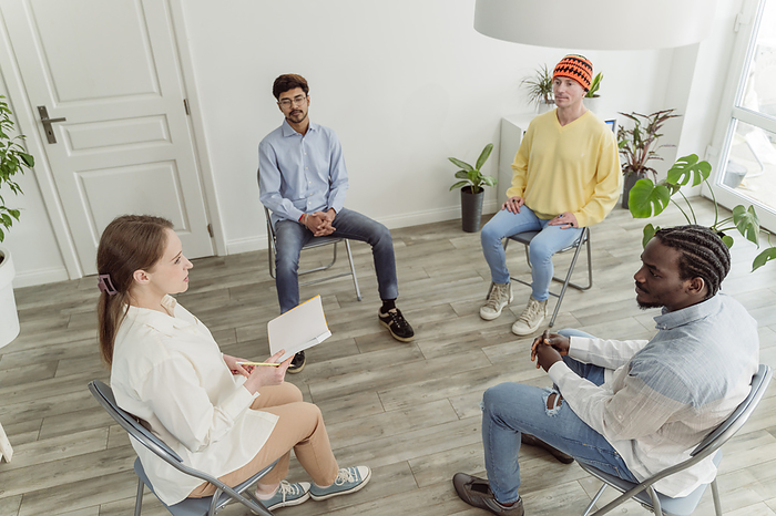 Psychologist discussing with man in group therapy