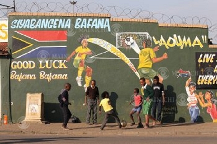 One week before the start of the World Cup in South Africa, children enjoy playing soccer in the former black neighbourhood of Soweto. In the former black neighbourhood of Soweto, hand painted pictures celebrating the World Cup were painted on the wall, and children were enjoying playing soccer in front of the wall in the suburbs of Johannesburg, South Africa. Photo by Junichi Sasaki at 3:15 p.m. on June 2, 2010.