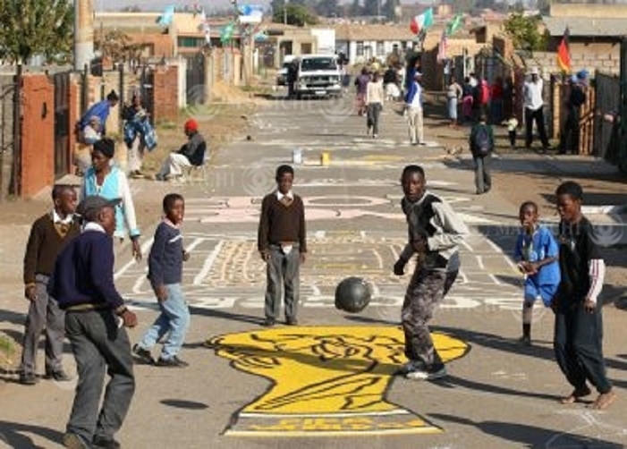  Eye  Soccer World Cup in South Africa: Children play soccer on a road with the trophy painted on it. In Soweto, a former black neighbourhood, children enjoy playing soccer on a road painted with the World Cup trophy, in the suburbs of Johannesburg, South Africa, 2010. Photo by Junichi Sasaki, June 2, 2010