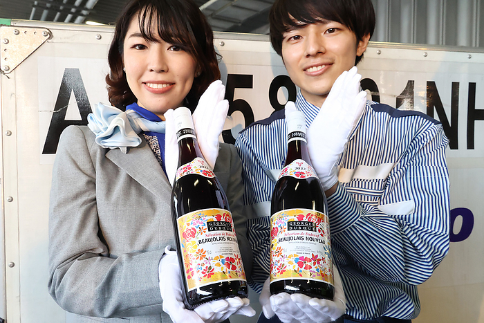 The first shipment of 2022 vintage Beaujolais Nouveau arrives at Haneda airport October 19, 2022, Tokyo, Japan   All Nippon Airways  ANA  ground staff  L  and cargo staff  R  display bottles of 2022 vintage Beaujolais Nouveau wine after the first shipment of the wine arrived at the Haneda airport in Tokyo on Wednesday, October 19, 2022. The first shipment of 3,192 bottles of the 2022 vintage wine arrived as the wine s embargo will be removed on November 17.       Photo by Yoshio Tsunoda AFLO 
