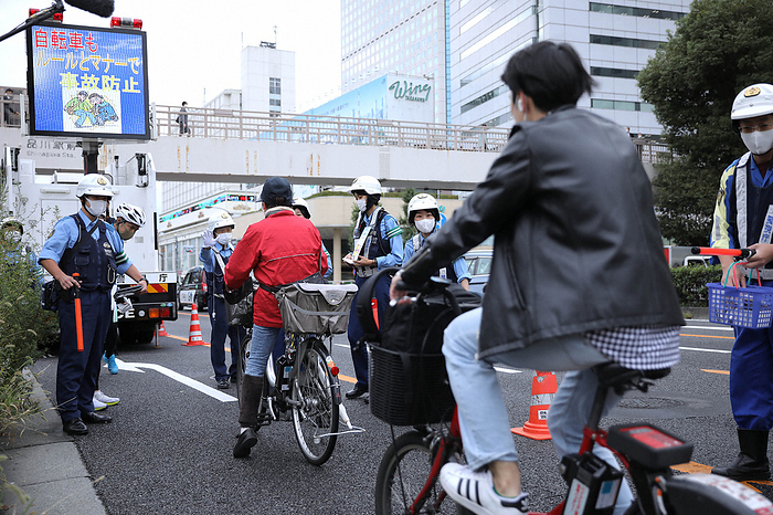 Police officers stop people riding bicycles and urge them to ride safely. Police officers stop people riding bicycles and call for safe driving in Minato Ward, Tokyo, October 1, 2022. Photo by Yuki Miyatake, 8:49 a.m., October 9, 2022